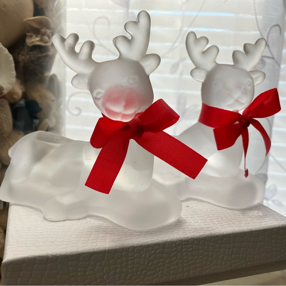 ST NICHOLAS SQUARE CHRISTMAS GLASS REINDEER CANDLE HOLDERS WITH A RED RIBBON.
